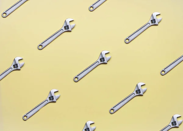 O padrão de chaves ajustáveis em um fundo amarelo . — Fotografia de Stock