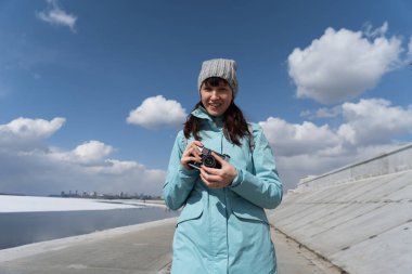 Bahar yürüyüşte: mavi bir ceket bir kız set yürür ve eski bir film kamera fotoğraf çeker.