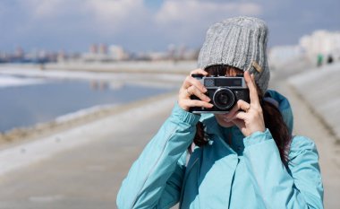 Bahar yürüyüşte: mavi bir ceket bir kız set yürür ve eski bir film kamera fotoğraf çeker.