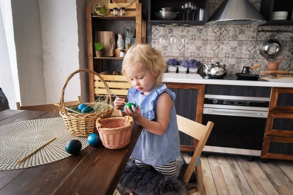 Velikonoce: dítě dívka a chlapec malovat na vejce s kartáčem v kuchyni. — Stock fotografie