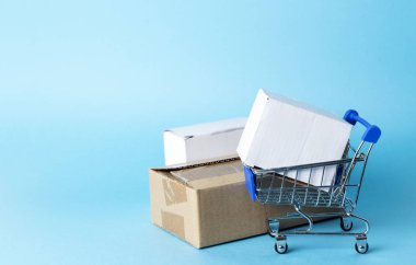 Mavi arka planda bir süpermarketten boş minyatür arabası.