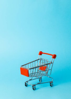 Kadın alışverişi: mavi arka planda süpermarketten alınmış boş bir minyatür kırmızı tramvay..