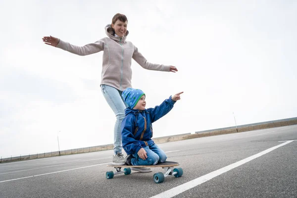 Moeder en zoon rijden mee op een groot Longboard. — Stockfoto