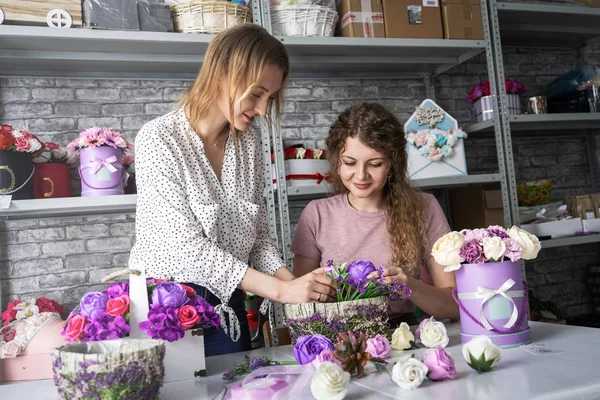 Dos niñas recogen un ramo de flores de rosas y peonías en su taller . — Foto de Stock