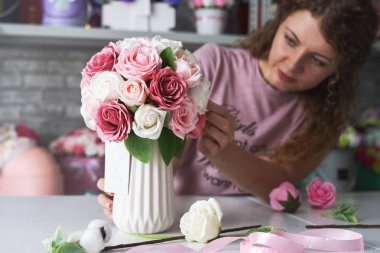 Çiçek Atölyesi: bir çiçekçi kız sipariş kutuları çiçekler buketleri yapar.