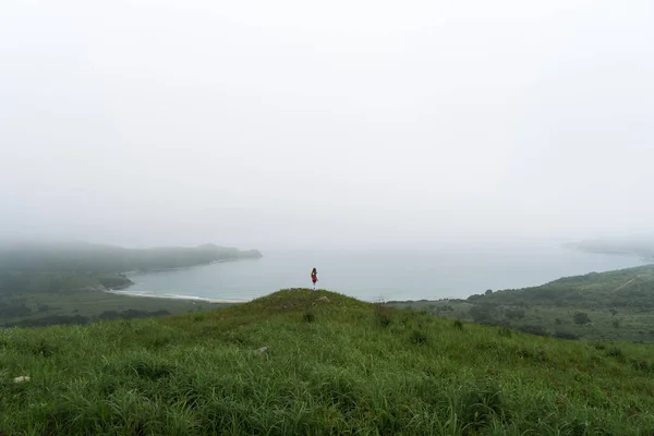 Bahía de mar cubierta de niebla con una pequeña figura de viajero en el centro de la imagen . —  Fotos de Stock