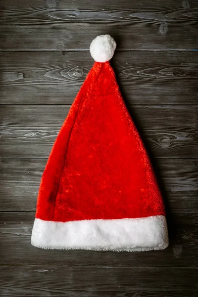 Mikołaj czerwony kapelusz na zielonym tle drewnianych. — Zdjęcie stockowe
