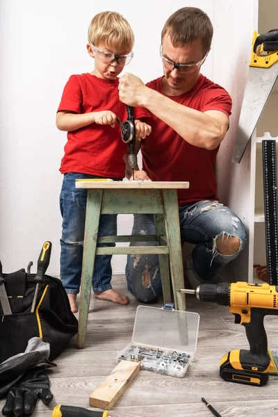 Baba oğluna el matkabıyla çalışmayı öğretiyor..