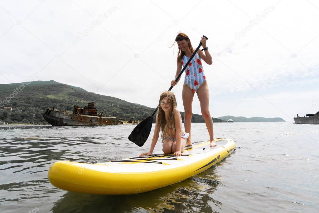 Mom and daughter ride a glanders board.