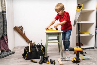 Küçük bir çocuk bir planör ile eski bir tabure planlıyor.
