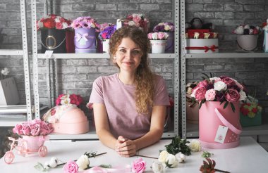 Çiçek Atölyesi: bir çiçekçi kız sipariş kutuları çiçekler buketleri yapar.