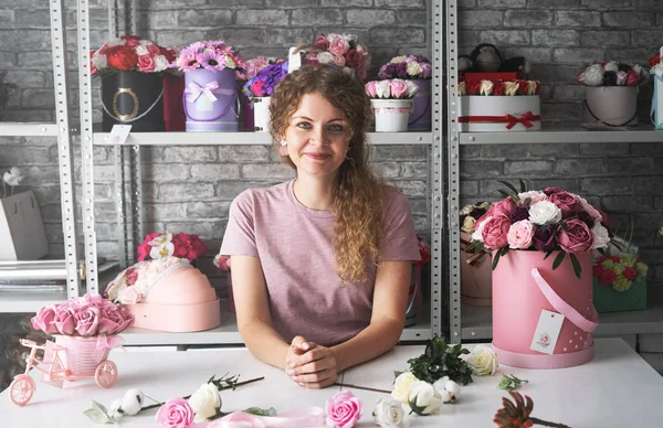 Çiçek Atölyesi: bir çiçekçi kız sipariş kutuları çiçekler buketleri yapar.