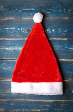 Mavi ahşap arka plan üzerinde Kırmızı Noel Baba şapka.