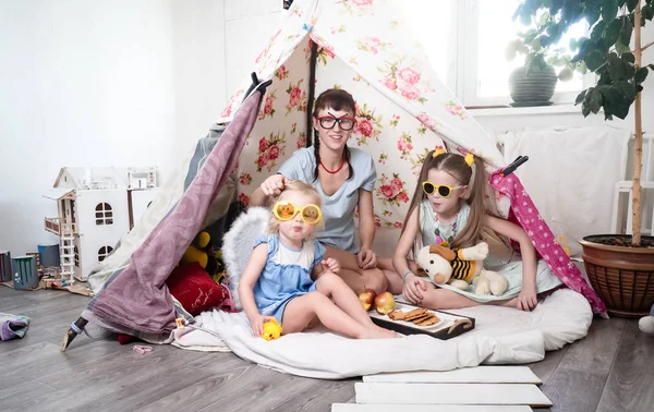 Czas dla rodziny: Mama, a niektóre siostry dzieci gry w domu w namiocie w domu dla dzieci. — Zdjęcie stockowe