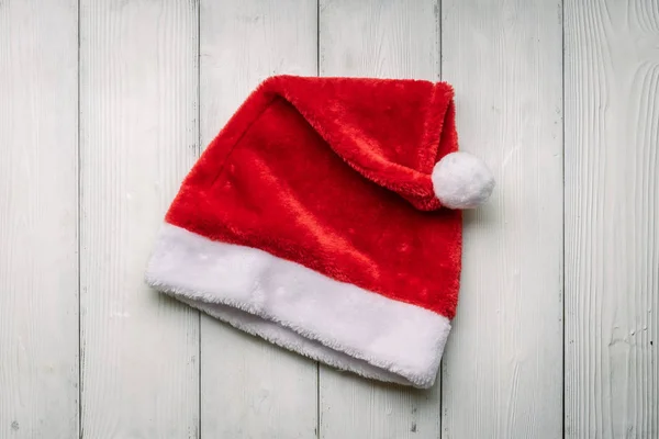 Red Santa Claus hat on a white wooden background. — Stock Photo, Image