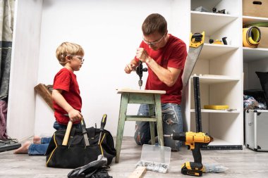 Baba oğluna el matkabıyla çalışmayı öğretiyor..