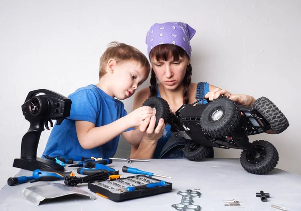 Kadın erkek çalışmalarında: Anne radyo kontrollü adamcağız model sabitleme ile oğlu yardımcı olur.