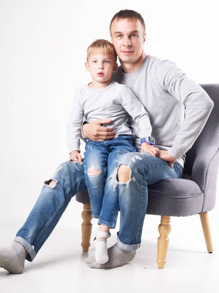 Family studio portrait of father and son in identical clothes.