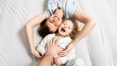 Aile zamanı: Anne ve kızı yatakta uzanmış neşeyle sarılıp gülüyorlar..