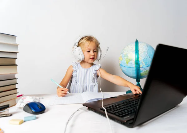 A girl in quarantine with a laptop is undergoing school training remotely.