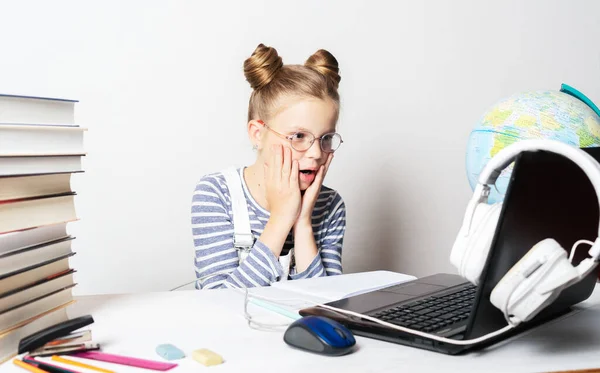 A girl in quarantine with a laptop is undergoing school training remotely.