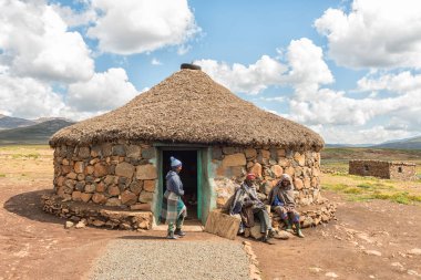 BLACK MOUNTAIN PASS, LESOTHO - MARCH 24, 2018: Unidentified Basotho people in front of a shop in the Mamokae village at the foot of the Black Mountain Pass clipart