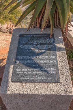 Pretoria, Güney Afrika, 31 Temmuz 2018: bir granit bilgi plak, Fort Schanskop Pretoria Komutan Piet Joubert Anıtı. Bir aloe görülür