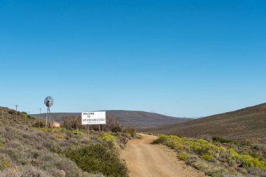 Hoş geldiniz işareti, yel değirmeni ve baraj, Ceres, Batı Cape Eyaleti R356 yolda bir manzara.