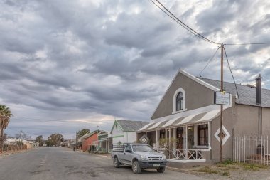 Carnavon, Güney Afrika, 1 Eylül 2018: Kuzey Cape Eyaleti Carnavon'da eski evlerle birlikte sabah ın erken saatlerinde sokak sahnesi. Araçlar görünür
