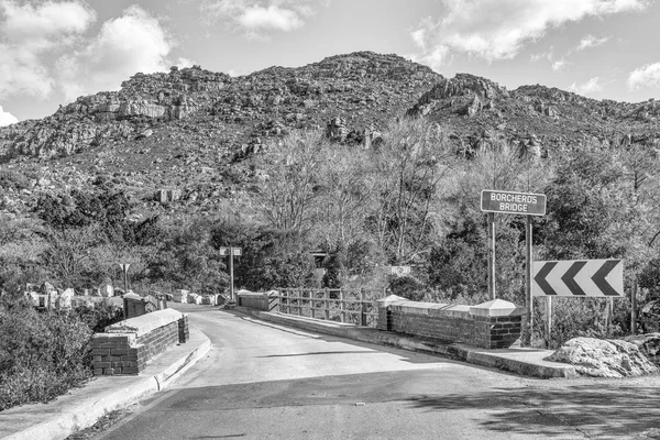 A single lane road bridge, called Borcherds Bridge, the historic Bains Kloof Pass in the Western Cape Province. Monochrome