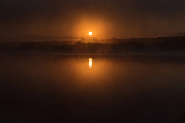 Sun rises through the fog on the dam at Vrede — Stock Photo, Image