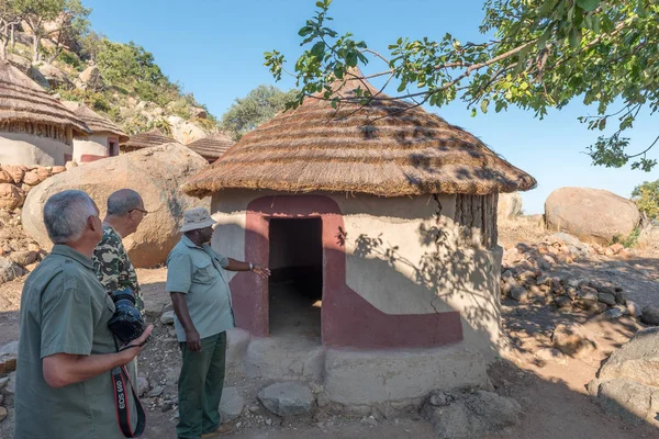 Toeristen en gids bij gereconstrueerd IJzertijd huis in Masorini — Stockfoto