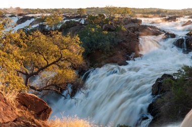 Kunene Nehri 'ndeki Ruacana şelalesinin tepesinden gün batımı manzarası