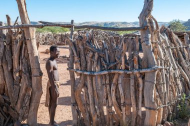 DAMARALAND, NAMIBIA - 30 Mayıs 2011: Damaraland, Namibya 'daki Damara Canlı Müzesi' nin girişinde geleneksel giysiler içinde bir Damara erkeği görülüyor