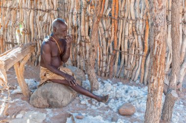 DAMARALAND, NAMIBIA - 30 Mayıs 2011: Damaraland, Namibya 'daki Damara Yaşayan Müzesi' ndeki bir atölyede bir Damara adamı