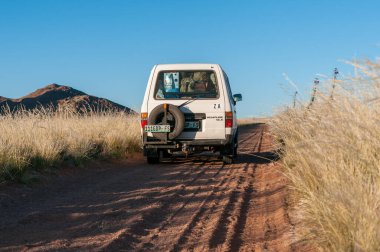 KOIIMASIS, NAMIBIA - 12 Haziran 2011: Koimasis Çiftliğine giden yol. Bir araç görünüyor.