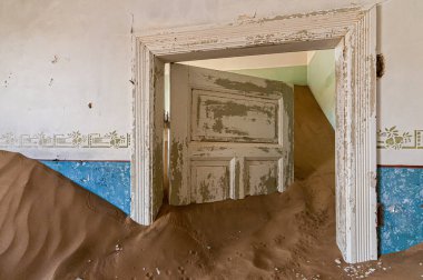 Kolmanskop 'ta çürüyen mimari, Luderitz yakınlarında terk edilmiş bir elmas madenciliği kasabası.