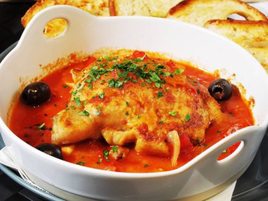 Beyaz bir kase üzerinde domates soslu sebzeli tavuk komposto        