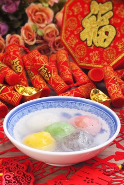 Beş-lezzet yapışkan pirinç topları Chines Bahar Festivali için kırmızı zemin üzerine bir kase 