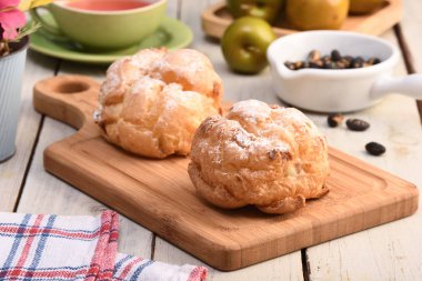 Bir kesme tahtası üzerinde lezzetli krem puffs .