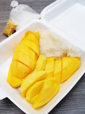 Ahşap masada köpük kutusunda Mango yapışkan pirinç 