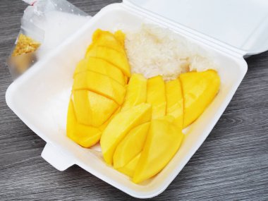 Ahşap masada köpük kutusunda Mango yapışkan pirinç     