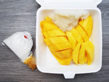 Ahşap masada köpük kutusunda Mango yapışkan pirinç 