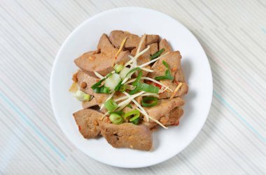 Beyaz tabakta domuz ciğeri salatası 