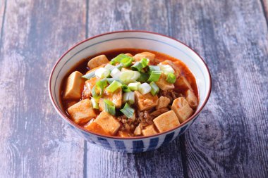  Rustik ahşap bir masada mapo doufu ile pirinç bir kase 