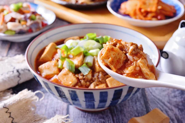  Rustik ahşap bir masada mapo doufu ile pirinç bir kase 