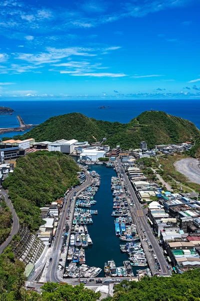 Mavi gökyüzünün altında, Nanfangao Balıkçı Limanı 'na bakan, demirli balıkçı tekneleriyle dolu..