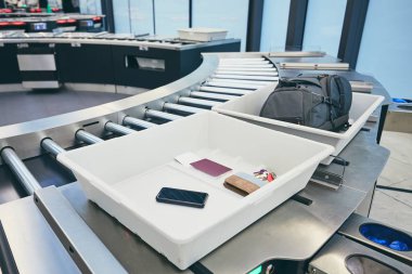 Havaalanı güvenlik kontrolü. Kapları ile x-ray kontrol önce kişisel eşyalar (pasaport, akıllı telefon, cüzdan, anahtarlar). 