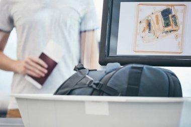 Havaalanı güvenlik kontrolü. Genç adam holding pasaport ve x-ışını için bekleyen onun Bagaj kontrol.