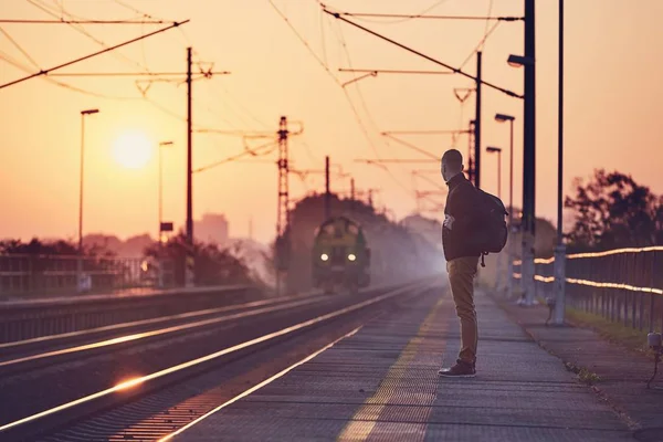 Demiryolu Stasyonu Platformu Güneş Doğarken Bekleyen Sırt Çantası Ile Yalnız — Stok fotoğraf